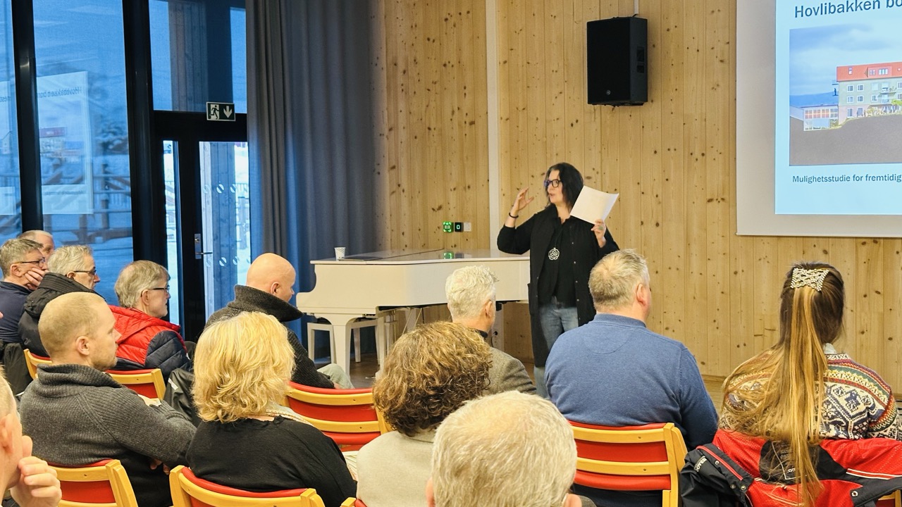 Vi ser prosjektleder for bærekraftig boligutvikliing, Tone Gellein, foran de fremmøtte. Presentasjonen er projeksjert til øyre bak henne.