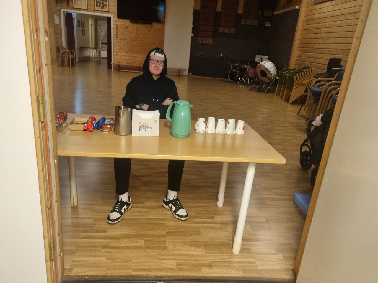 Lærlingen Kristoffer Engevold sitter på en stol og serverer kaffe
